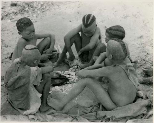 [No folder title]:  Boys of Oukwane's group and "visiting group" sitting by a fire




