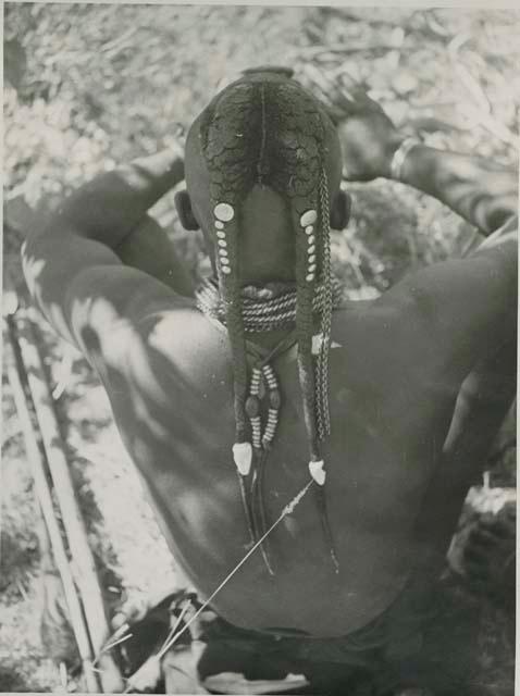 "1950 '400 Series' / 41 prints": Girl sitting with her back to the camera, showing hairstyle (print is a cropped image)