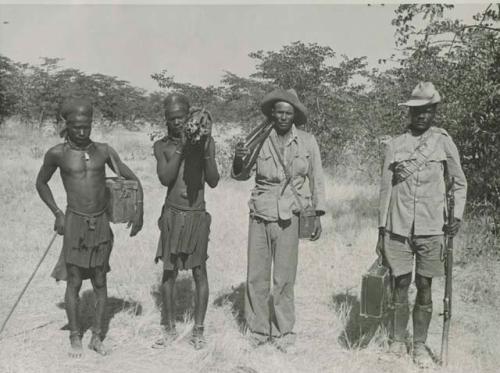 "1950 '400 Series' / 41 prints": Four men standing and holding guns and cases (print is a cropped image)