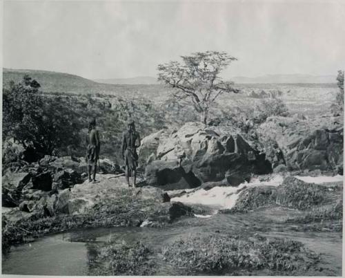 "1950 '400 Series' / 41 prints": Two men standing on the rocks at the top of Ruacana Falls (print is a cropped image)