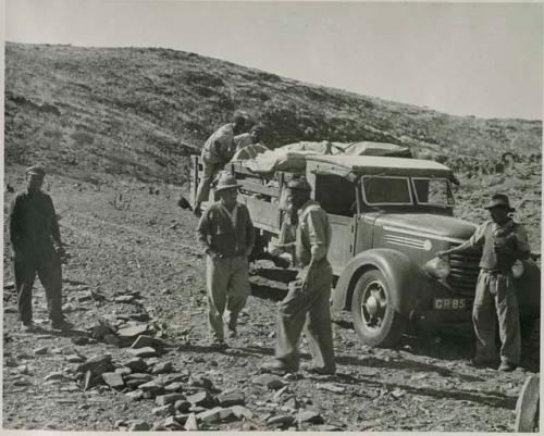 "1950 400 series  43 prints / Kunene River, Kaokoveld, Ovamboland / Merle LaVoy & L.K.M": Expedition members standing in front of truck (print is a cropped image)