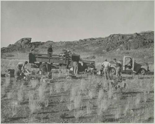 "1950 400 series  43 prints / Kunene River, Kaokoveld, Ovamboland / Merle LaVoy & L.K.M": Expedition members working next to trucks (print is a cropped image)