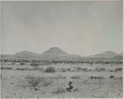 "1950 400 series  43 prints / Kunene River, Kaokoveld, Ovamboland / Merle LaVoy & L.K.M": Small pile of rocks, with hills in the distance (print is a cropped image)