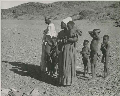 "1950 400 series  43 prints / Kunene River, Kaokoveld, Ovamboland / Merle LaVoy & L.K.M": Group of women and children standing (print is a cropped image)