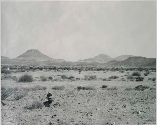 "1950 400 series  40 prints / Kaokoveld": Small pile of rocks, with hills in the distance (print is a cropped image)