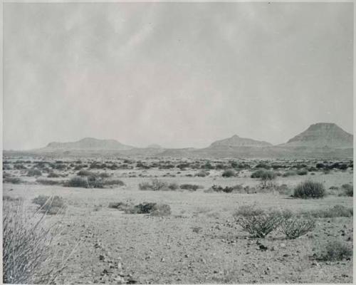 "1950 400 series  40 prints / Kaokoveld": Small pile of rocks, with hills in the distance (print is a cropped image)