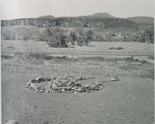 "1950 400 series  40 prints / Kaokoveld": Pile of stones in circle with space for entrance (print is a cropped image)