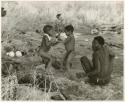 [No folder title]: "Gao Medicine", seated, "Little ≠Gao", /Gaishay (Di!ai's and "Gao Medicine's" son), and other unidentified people in the background (print is a cropped image)