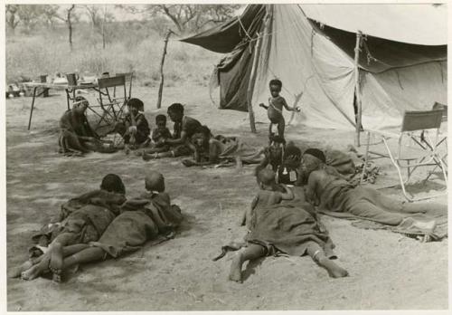 [No folder title]: People lying in front of one of the expedition's tents (print is a cropped image)