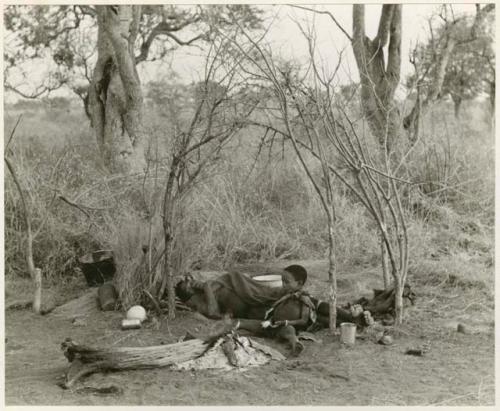 [No folder title]: "/Qui Navel" and his son, "Little ≠Gao," lying down beside a fire in the skerm (print is a cropped image)