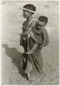 [No folder title]: Girl with a wreath of blossoms around her head, carrying a baby (print is a cropped image)