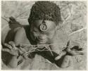 [No folder title]: Child holding a "cat's cradle" (print is a cropped image)