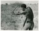 [No folder title]: "Crooked /Qui" demonstrating shooting an arrow, seen from the back (print is a cropped image)