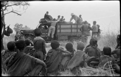 Expedition members including Laurence Marshall, John Marshall, Elizabeth Marshall Thomas, and William Donnellan, and Ju/'hoansi gathered around the truck