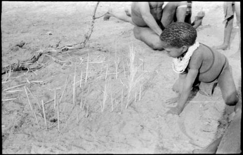 Boy looking at the sticks for constructing a playhouse