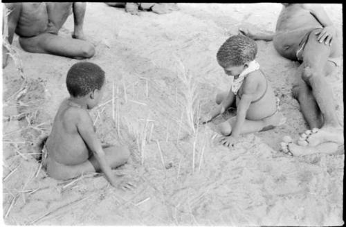 Two boys looking at the sticks for constructing a playhouse