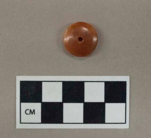 Ground stone, carnelian button