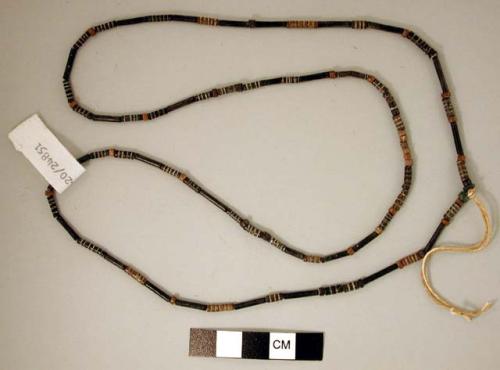 Necklace of small cylindrical beads, brown and black.  Beads possibly made of ba