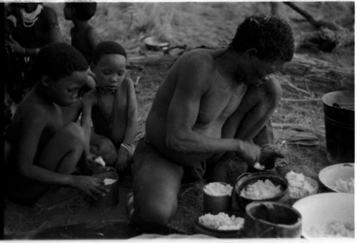 "Old Gau" distributing cooked mealies with !Ilaishi and "Little ≠Gao" (son of "/Qui Navel" and //Kushay) watching