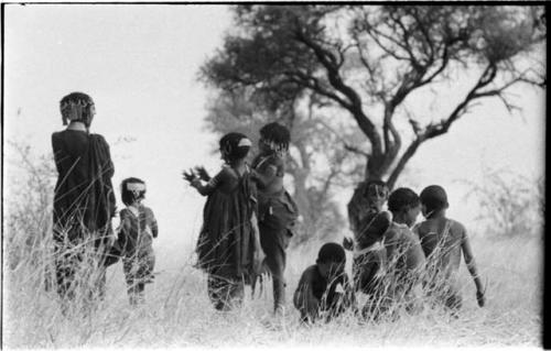 Boys dancing and girls clapping, seen from the back