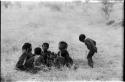 Girls clapping and singing in a circle and a boy dancing