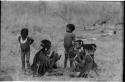 Girls clapping and singing in a circle, with a little boy dancing