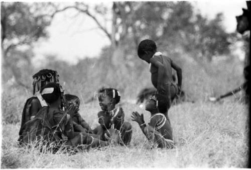 Girls clapping and singing, with a little boy dancing