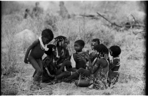 Girls clapping and singing, with a little boy dancing