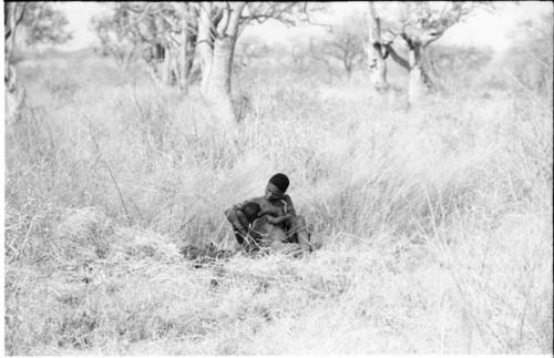 Woman nursing her child sitting in the grass