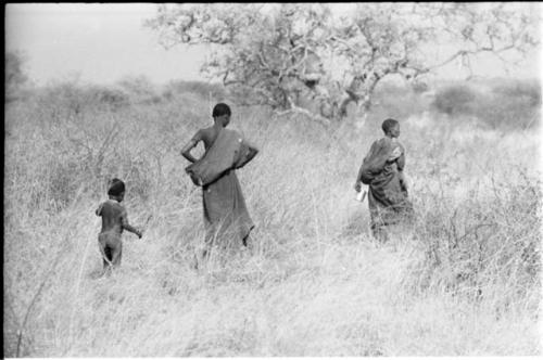 Two women and a child walking in the grass