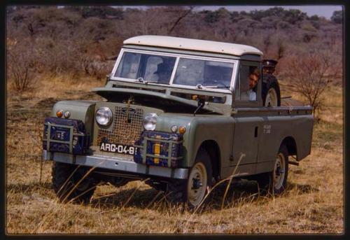 Pedro Imiljo looking through the window, sitting behind the wheel of Expedition Land Rover with other people