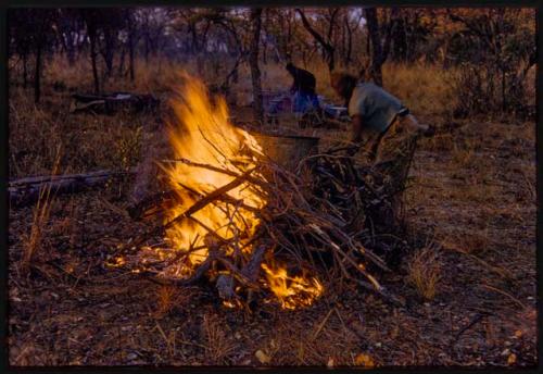 Boiling water drum on the fire, with a man standing next to it