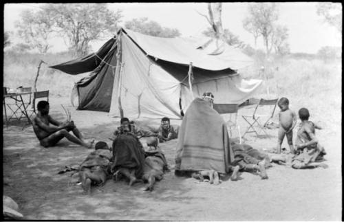 Group of Ju/'hoansi lying in front of one of the expedition tents