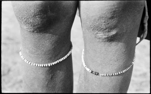 Bead bracelets under a person's knees