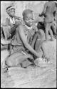 Visiting girl seated with a piece of veldkos