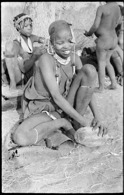 Visiting girl seated with a piece of veldkos