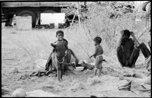 "Gao Medicine" and /Naoka (his first wife) along with their two children sitting in front of the expedition's truck