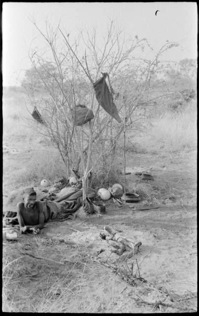 "/Gao Music" lying beside his fire keeping his belongings nearby