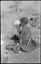 "Old Xama" holding an ostrich egg to her eye to see how clean it is inside