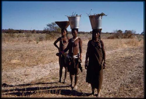 Women carrying buckets of water on their heads