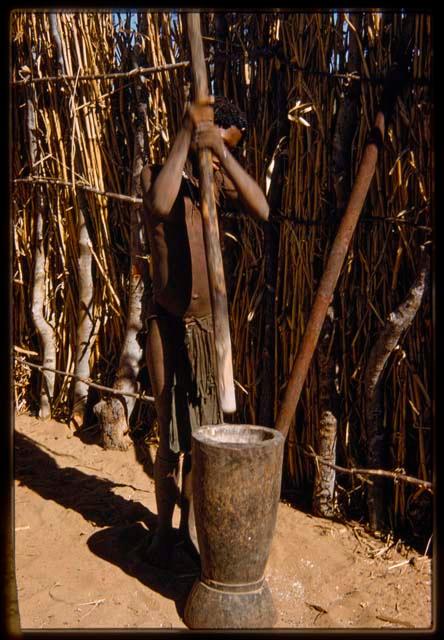 Girl pounding millet