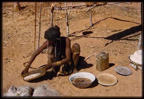 Woman sitting next to a container of millet