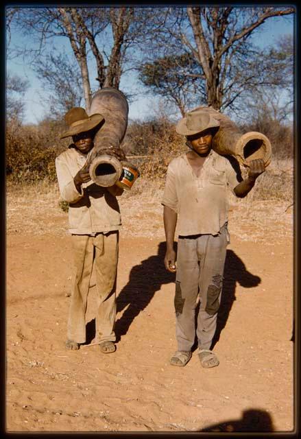 Two men standing and holding drums