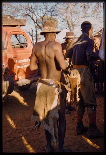 Three men dancing, with the expedition truck in the background