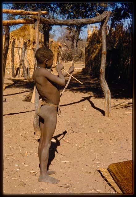 Boy standing and holding a bow and arrow