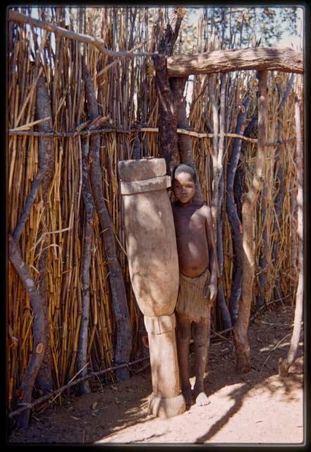 Boy standing next to a drum