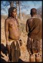 Woman from Ndongo standing, profile, with another woman standing with her back to the camera