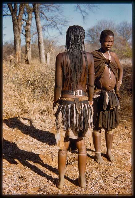 Woman from Ndongo standing with her back to the camera, with another woman standing next to her