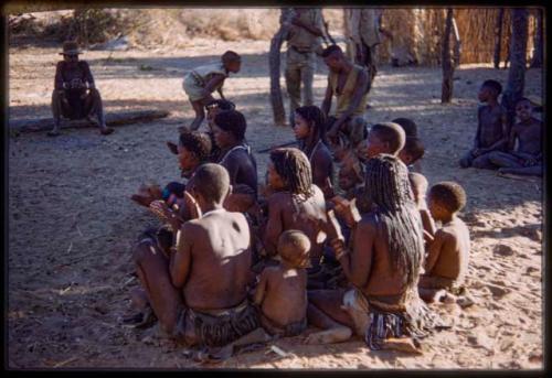 Group of women sitting with children, clapping