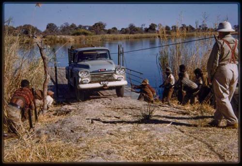 Men pulling a truck off the pont (ferry) at Bagani